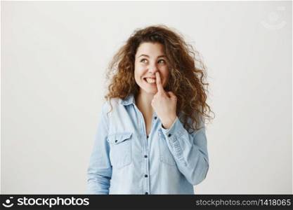 Young girl standing isolated on grey wall playing around looking camera smiling happy close-up.. Young girl standing isolated on grey wall playing around looking camera smiling happy close-up