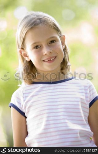 Young girl standing outdoors smiling