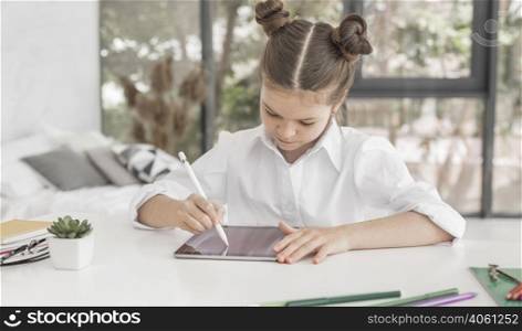 young girl studying tablet with pen