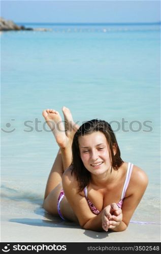 young girl sunbathes on a beach