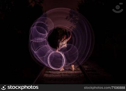 Young girl surrounded by frozen light. Drawing with light. Long exposure. Artistic abstraction. Freezelight.. Young girl surrounded by frozen light. Drawing with light. Long exposure. Artistic abstraction. Freezelight