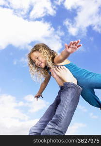 Young girl swirling feet in the air