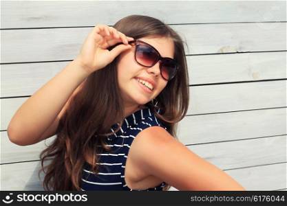 Young girl Teenager with a wooden fence, a trendy stylish portrait