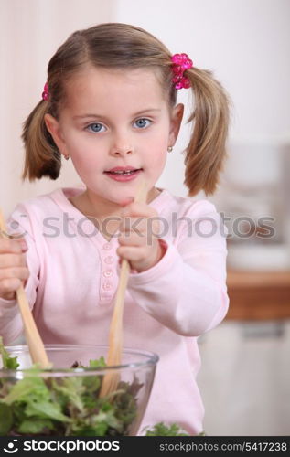 Young girl tossing a salad