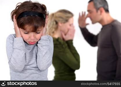 Young girl trying to block out the sound of her parents arguing