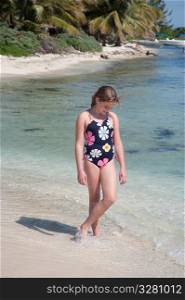 Young girl walking along beach at Belizean Isle in Belize