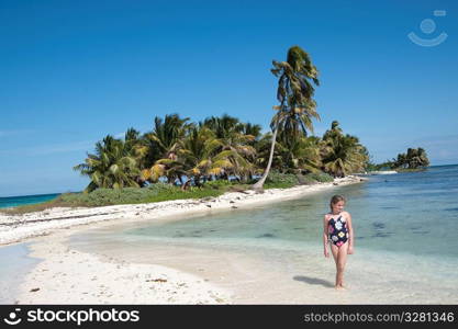 Young girl walking along beach at Belizean Isle in Belize