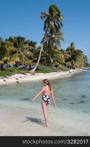 Young girl walking along beach at Belizean Isle in Belize