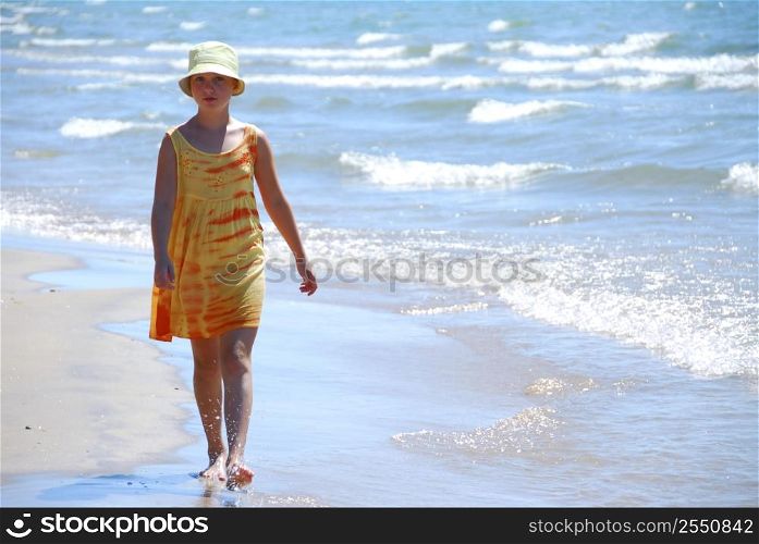 Young girl walking on a beach