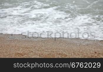 Young girl walking on the beach with waves