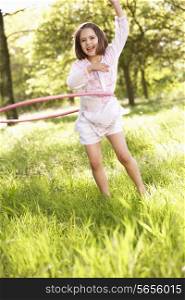Young Girl Walking Playing With Hula Hoop In Summer Field