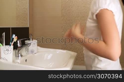 Young girl washing her face in the bathroom