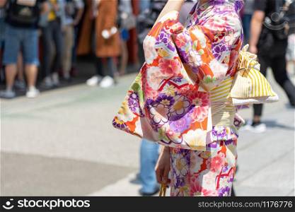 "Young girl wearing Japanese kimono standing in front of Sensoji Temple in Tokyo, Japan. Kimono is a Japanese traditional garment. The word "kimono", which actually means a "thing to wear" "