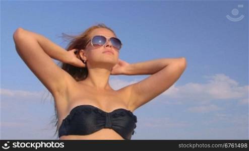 Young girl wearing sunglasses enjoying summer vacation on the beach