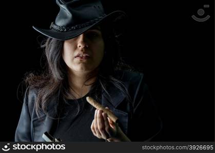 Young girl with a cigar in her mouth wearing black leather jacket and hat and looking at the camera
