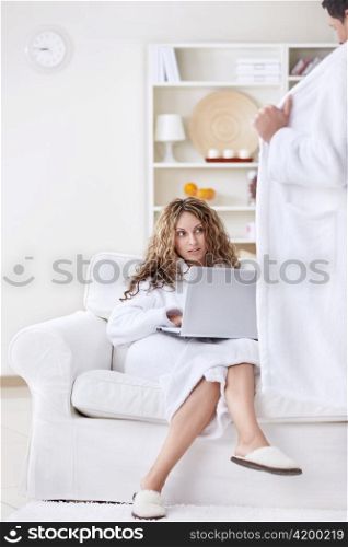Young girl with a laptop looking at the man, opened its robe