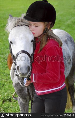 Young girl with a white pony at countryside