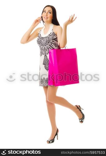 Young girl with bags talks by mobile phone isolated