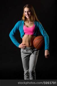 Young girl with basketball ball on black