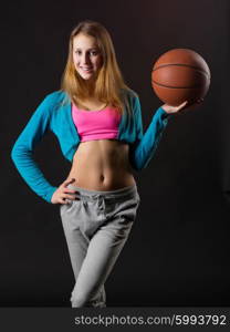 Young girl with basketball ball on black