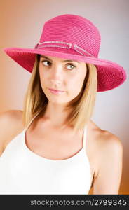 Young girl with beach hat against gradient background