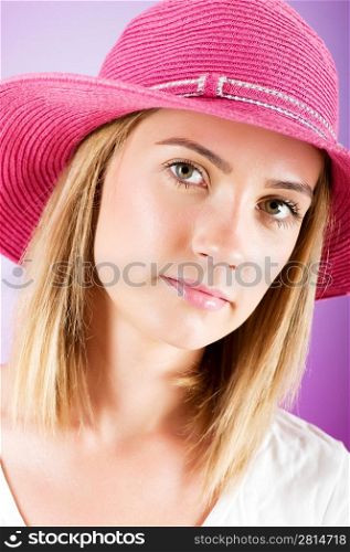 Young girl with beach hat against gradient background