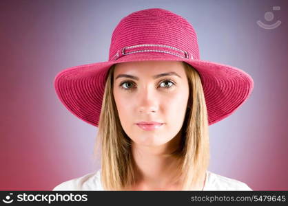 Young girl with beach hat against gradient background