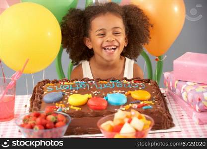 Young girl with birthday cake and gifts at party