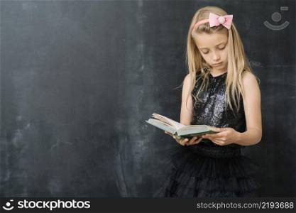 young girl with book chalkboard