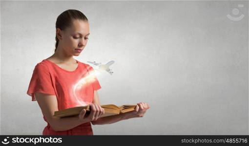 Young girl with book. Young woman in red dress with book in hand and airplane flying from pages