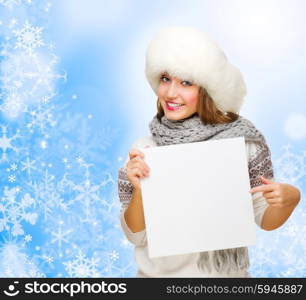 Young girl with empty card on blue winter background