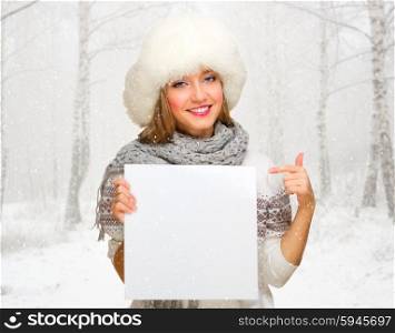 Young girl with empty poster at snowy winter forest