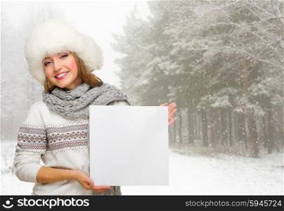 Young girl with empty poster at winter forest