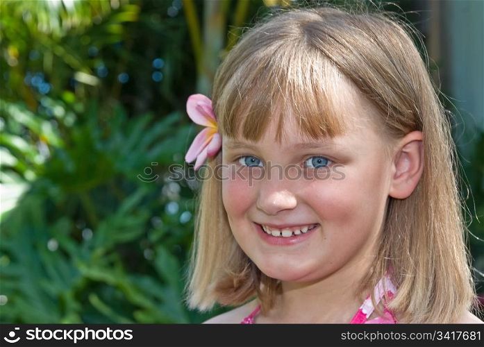 young girl with frangipani in her hair. tropical girl