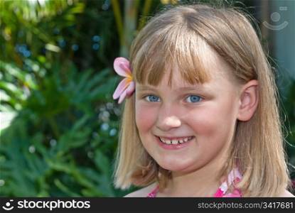 young girl with frangipani in her hair. tropical girl