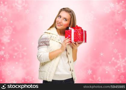 Young girl with gift box on winter background