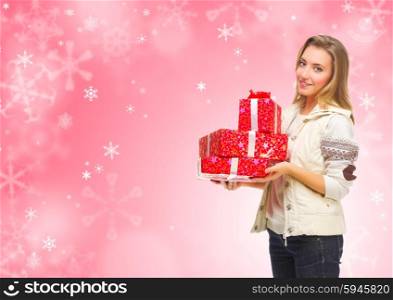 Young girl with gift boxes on winter background