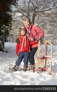 Young Girl With Grandmother Holding Sledge In Snowy Landscape