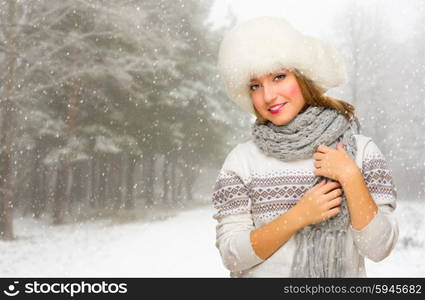 Young girl with hat at snowy winter forest