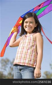 Young girl with kite outdoors smiling