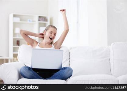 Young girl with laptop yawns
