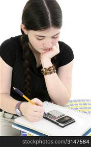 Young girl with long black hair doing her homework at table.
