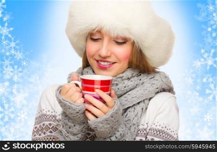 Young girl with mug on winter background