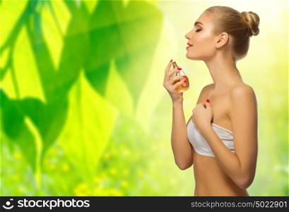 Young girl with perfume on floral background