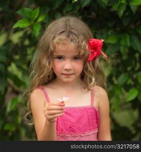 Young girl with pink flower in her hair at Moorea in Tahiti