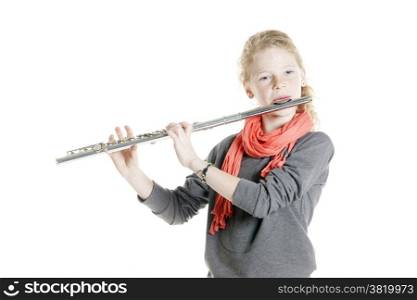 young girl with red hair and freckles plays flute in studio against white background