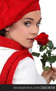 young girl with red rose and assorted winter clothing