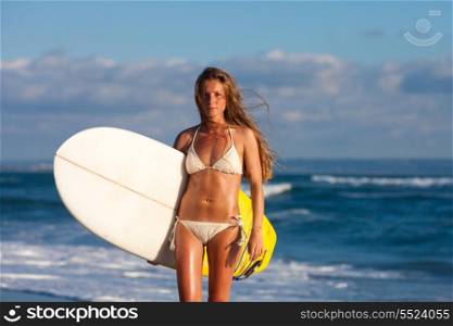 young girl with surfboard at the beach.Bali.Indonesia.