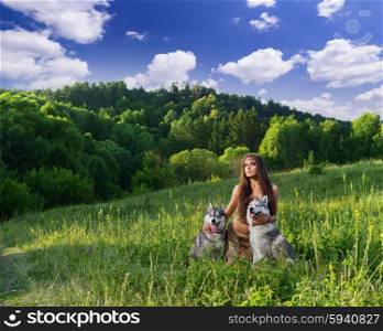 Young girl with two dogs at meadow