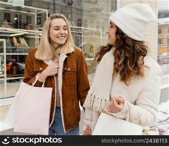 young girlfriends outdoor with shopping bags